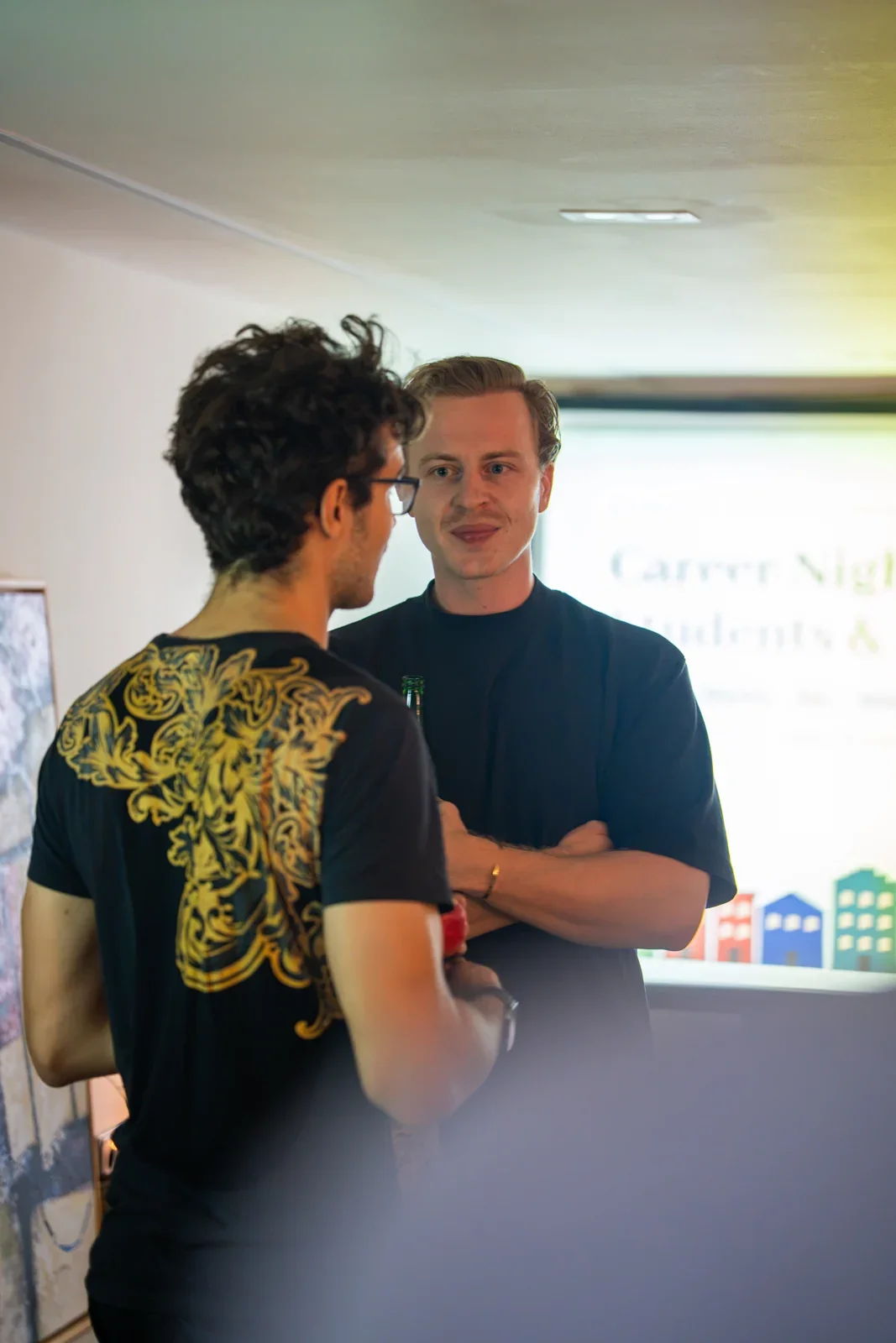 Two people talking next to the presentation screen