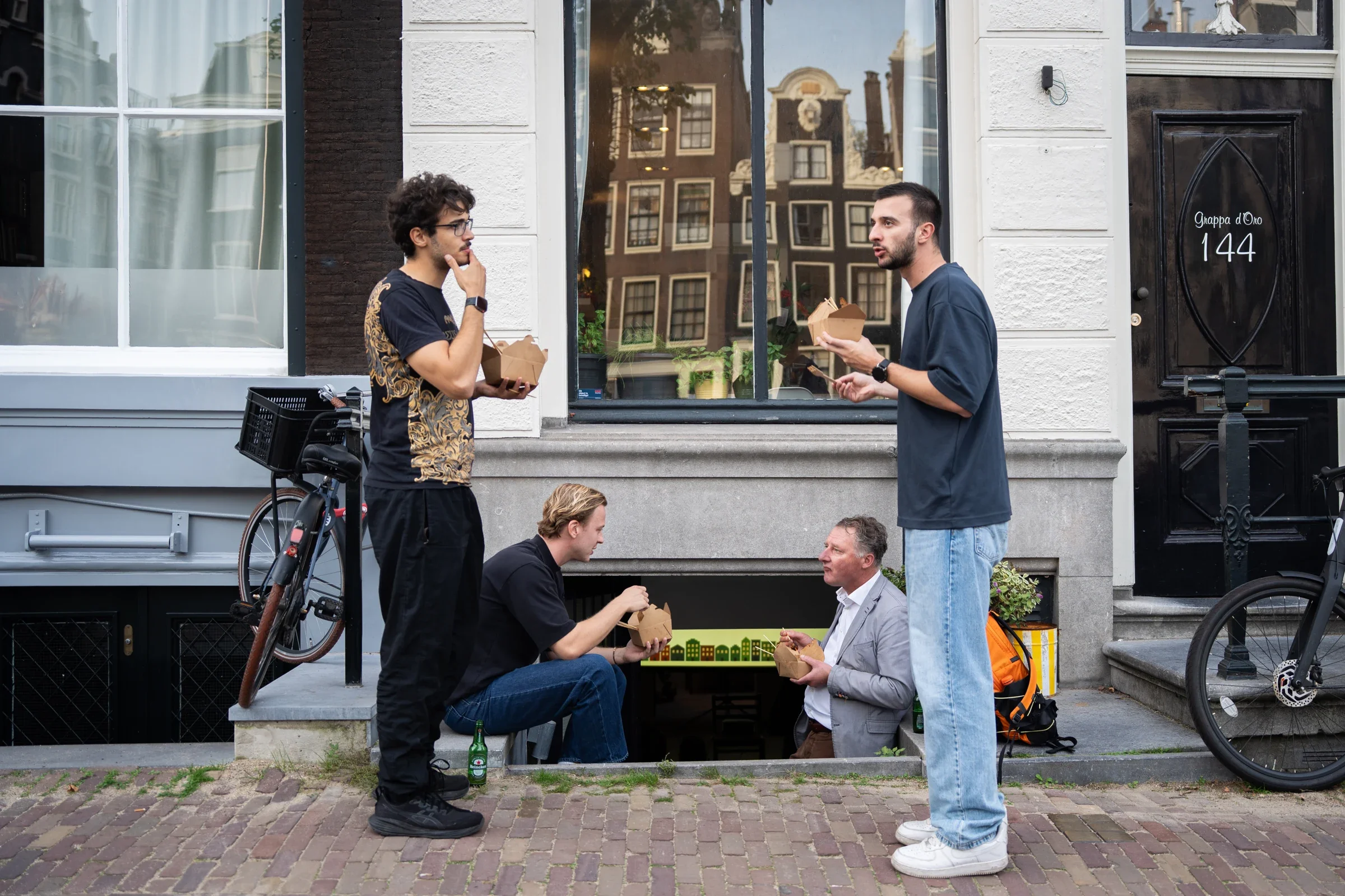 Visitors eating satay outside the office on the Herengracht
