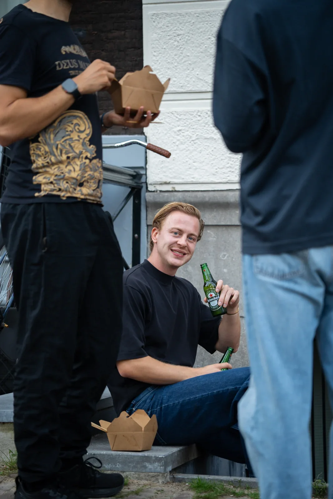 A visitor with a drink on the steps outside the office