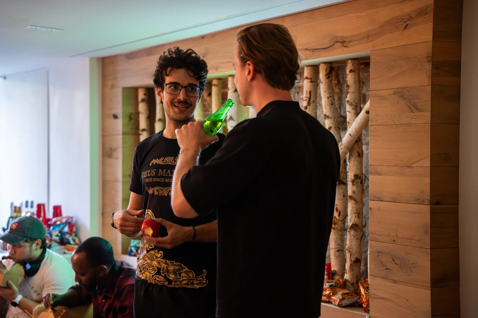 Twee bezoekers in gesprek bij de berkenwand
